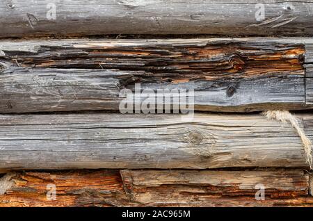 Old log wall. Texture of the wooden wall of an old house. Close up. Stock Photo