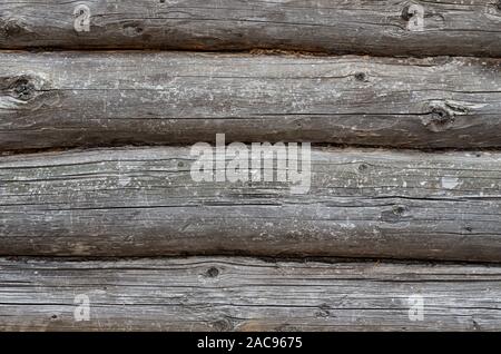 Old log wall. Texture of the wooden wall of an old house. Close up. Stock Photo
