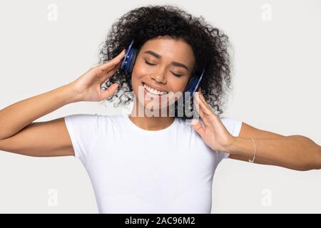 Smiling African American woman in headphones enjoying favorite music Stock Photo