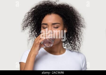 Thirsty young African American woman drinking clean mineral water Stock Photo