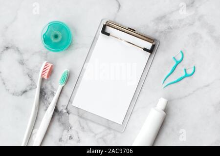 Set of pink and turquoise blue toothbrushes, toothpaste and other tools on marble background. Dental and health care concept. Top view, flat lay. Free Stock Photo