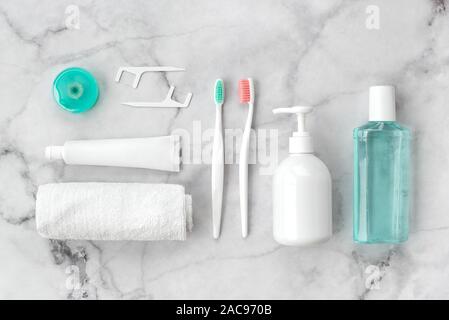 Set of pink and turquoise blue toothbrushes, toothpaste and other tools on marble background. Dental and health care concept. Top view, flat lay. Stock Photo