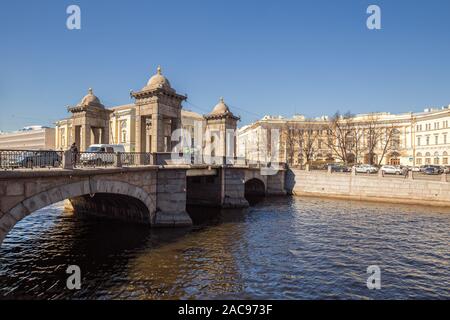 ST. PETERSBURG, RUSSIA - APRIL 18, 2019: Lomonosov bridge over the Fontanka with people and cars and Lomonosov Square. On square is building of the Mi
