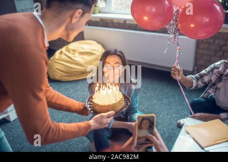 Boyfriend with cake. Student feeling surprised while seeing her boyfriend with birthday cake on her birthday Stock Photo