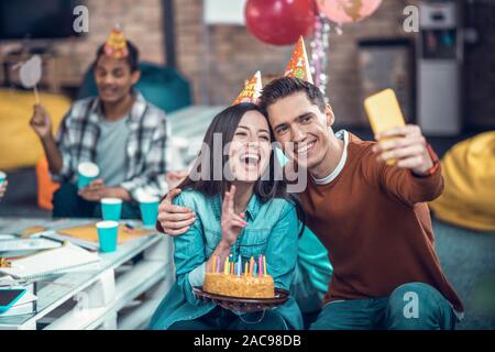 Photo with boyfriend. Birthday girl smiling while celebrating birthday and making photo with boyfriend Stock Photo