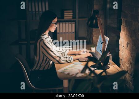 Photo of amazing asian business lady resourceful person looking notebook on table writing report sitting boss chair formalwear striped shirt night Stock Photo