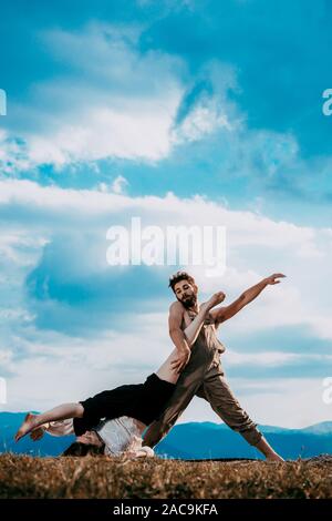 Two athletic young dancers making a performance at mountain peak Stock Photo
