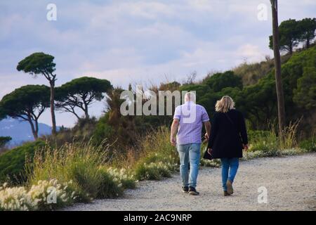 Elderly couple walking on a path outdoors. Carretera de les Aigües, Parc de Collserola, Barcelona, Spain. Stock Photo