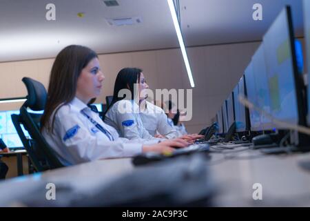 In the System Control Room, Technical Operator Works at His Workstation with Multiple Displays, Security guard working on multiple monitors. Stock Photo