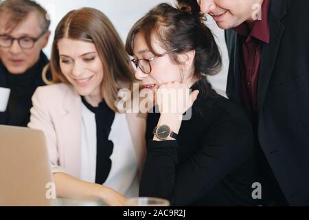 Beautiful female business women working on new project ideas within creative team in office. Group project for crowdfunding campaign. Stock Photo