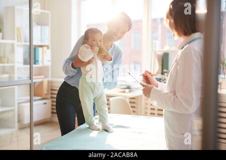 Mother and her baby visiting doctor at hospital Stock Photo