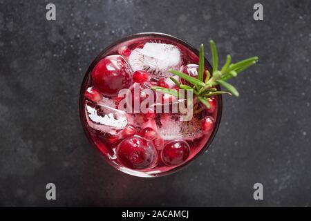 Pomegranate Rosemary Holiday Christmas cocktail with champagne, cranberry, club soda on black table. Close up. View from above. Stock Photo