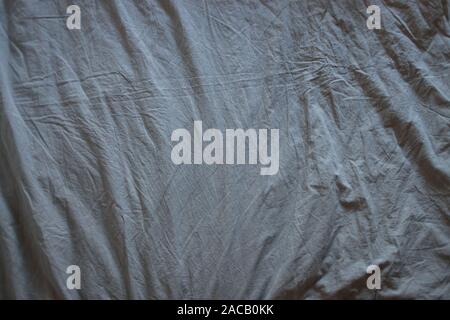 Texture of the morning gray crumpled sheet, top view Stock Photo