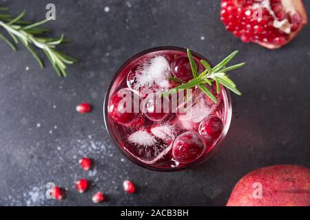 Pomegranate Rosemary Holiday Christmas cocktail with champagne, cranberry, club soda on black table. Close up. View from above. Stock Photo