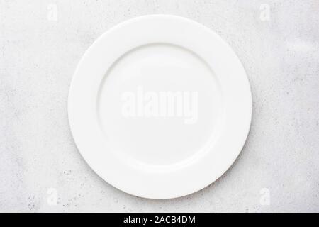 Empty white plate on grey cement concrete background with copy space, table top view. Design background for food menu, restaurant or cafe meal templat Stock Photo
