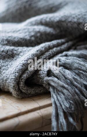 Warm and cozy winter knitted wool blanket with fringe, close-up Stock Photo