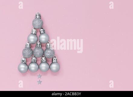 Christmas tree shape made of silver baubles and stars isolated on a pastel pink speckled background, with copy space Stock Photo