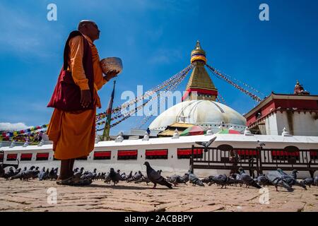 Panoramic view of the Boudha Stupa in the suburb Boudhanath, a tibetan monk collecting alms Stock Photo