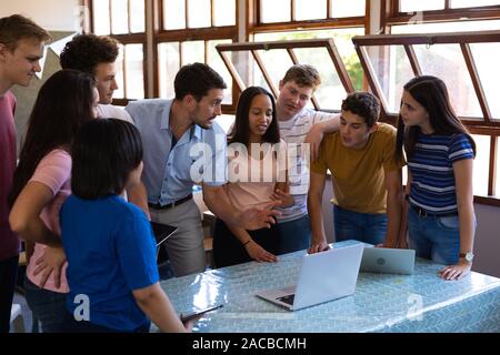 Teenagers and teacher in classroom Stock Photo