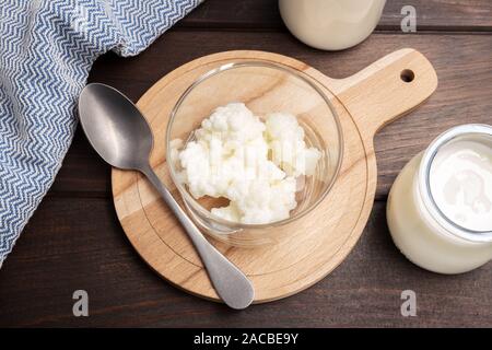 Milk kefir grains in jar on wooden table. Yeast bacterial fermentation starter Stock Photo