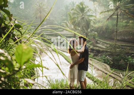 Young latin american couple with amazing view of Ubud rice terraces in morning. Happy together, honeymoon in Bali. Travel lifestyle. Stock Photo