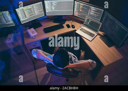 Hign angle above view photo of it skilled specialist guy sitting comfy office holding hands behind head looking many monitors testing team task Stock Photo