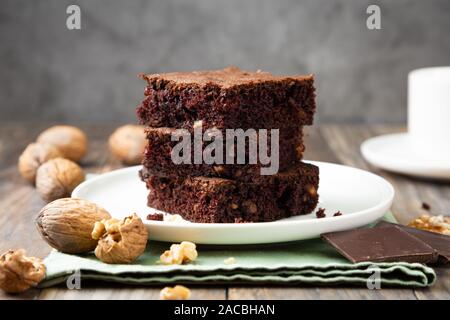 Chocolate brownie cakes with walnuts on a stack on a rustic wooden table Stock Photo