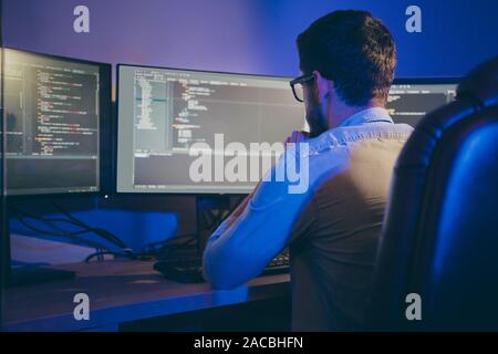 Rear back behind view portrait of nice focused skilled experienced guy thinking bug fixing debugging hardware software trouble shooting data secure Stock Photo