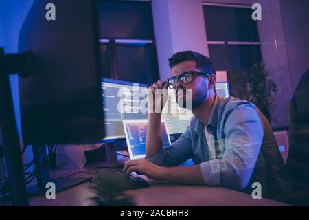 Profile photo of it specialist looking monitors testing website debugging system attentive developer expert creating new tasks for team sitting night Stock Photo