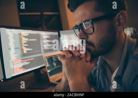 Profile photo of it specialist holding hands crossed fingers on chin looking monitors testing website debugging developer expert sitting night dark Stock Photo
