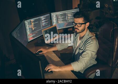 Profile side view of nice attractive serious smart clever bearded brunet guy sitting in chair editing creating database bug tracking report web Stock Photo