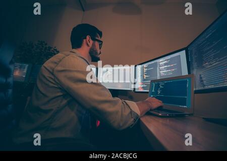 Low below angle view photo of it-specialist developing C code improving system of cyber security of corporation designing company web site back-end Stock Photo