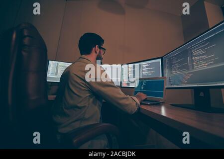 Profile side view of his he nice senior experienced skilled smart clever brunet guy providing tech support clients service desk in dark beige room Stock Photo
