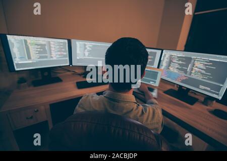 Back rear view photo of specialist designer using artificial intelligence to help himself develope software able to recognize outsource sorts sitting Stock Photo