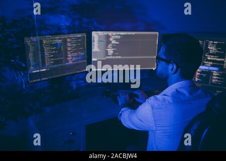 Profile side view of his he nice attractive clever smart skilled experienced top developer brunet guy processing outsource tech support in dark blue Stock Photo