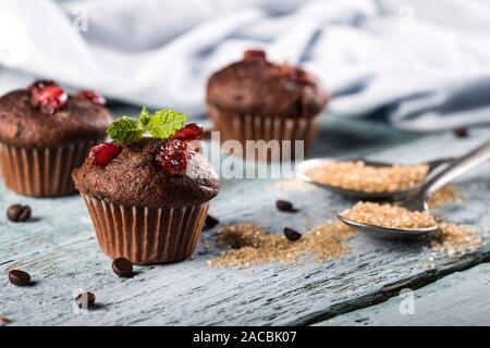 Chocolate fresh delicious muffins with cranberry on a blue wooden background. Stock Photo