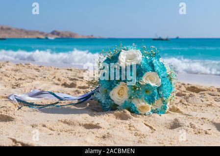 Brides bouquet bunch of flowers posy on sandy tropical beach romantic concept Stock Photo