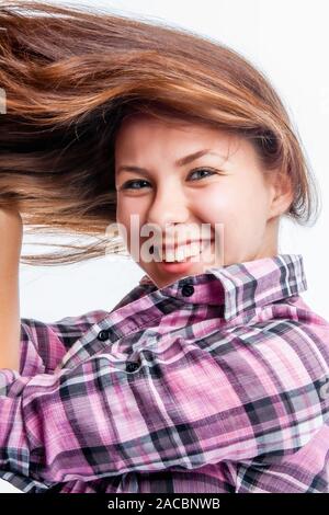 Portrait of smart and beautiful laughing girl with long luxurious hair fluttering in the wind Stock Photo