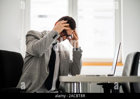 Young businessman is having headache. Stock Photo