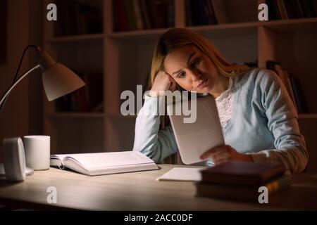 Student learning at home. Using digital tablet. Stock Photo