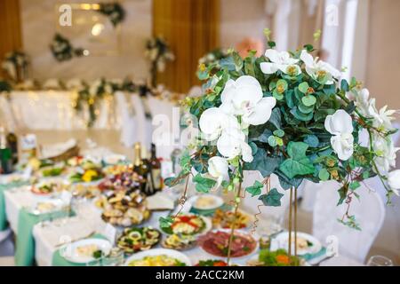 Beautiful flowers on elegant dinner table in wedding day. Decorations served on the festive table in blurred background Stock Photo