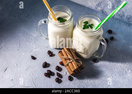 simple homemade kefir in a glass with spices and herbs on a gray background, copy space. Probiotic Ayran Stock Photo