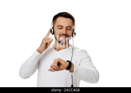 Call center worker man isolated on white background. Young smiling cute employee telesales agent using headset and looking at watch. Save your time - call customer service support