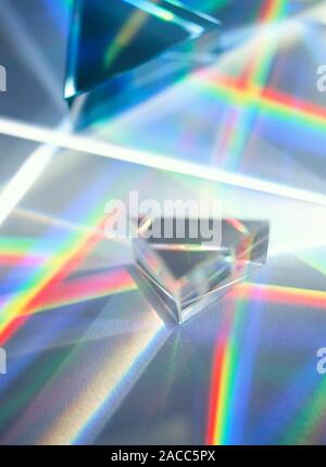 Refraction. White light being refracted as it passes through a triangular prism to produce a spectrum (rainbow). Refraction is the change of direction Stock Photo