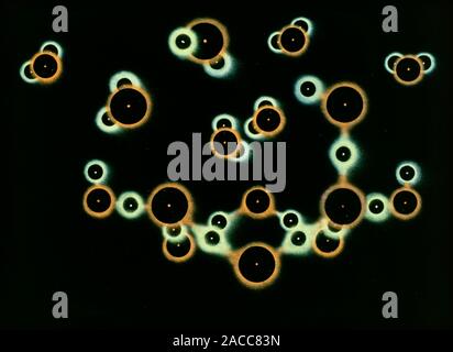 Water evaporating. Image 3 of 3. Artwork of water molecules evaporating from ice. The atoms are shown as balls here, and are colour coded: oxygen (red Stock Photo