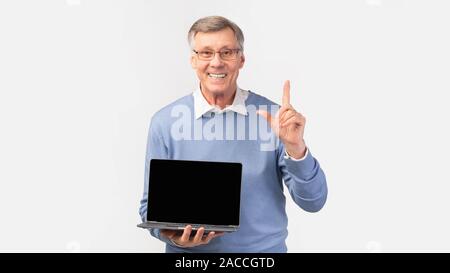 Senior Man Showing Laptop Blank Screen Standing, White Background, Panorama Stock Photo