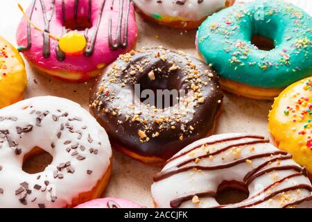 delicious donuts of different flavors on paper close up Stock Photo