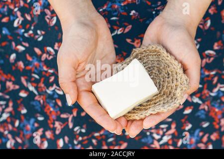 Eco-friendly cleaning kit. Organic soap and jute washcloth in the woman's hand. Zero waste concept, plastic-free, eco-friendly shopping, vegan Stock Photo