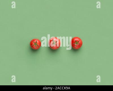 Red cherry tomatoes on light green background Stock Photo