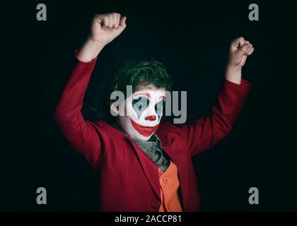 boy dressed as Joker on dark background Stock Photo